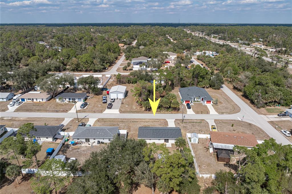 An aerial view shows a single-story house with a dark roof and a large backyard — 17235 URSULA AVENUE, PORT CHARLOTTE, FL