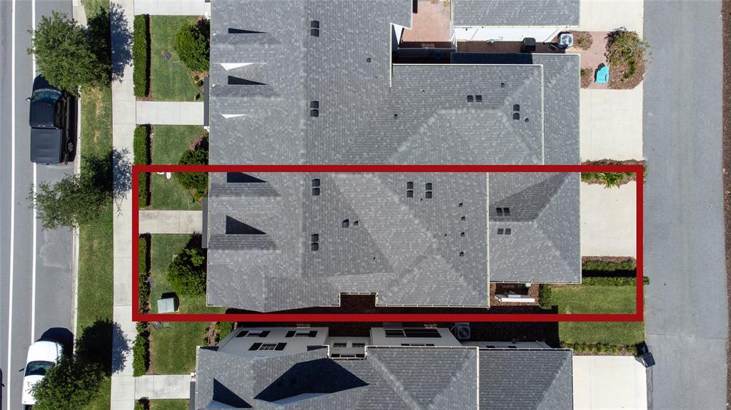An aerial view shows a residential building with a gray shingled roof highlighted by a red rectangle — 2101 CELEBRATION BOULEVARD, KISSIMMEE, FL