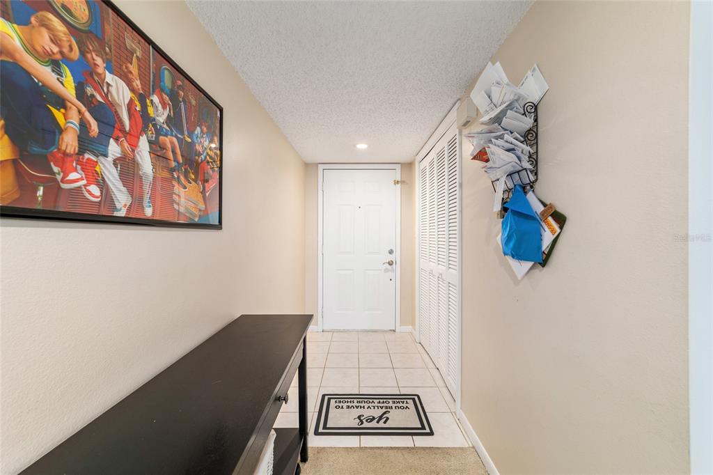 An entryway features a black console table, a framed poster, and a shoe-removal floor mat — 2845 SW 32ND AVENUE UNIT B3, OCALA, FL