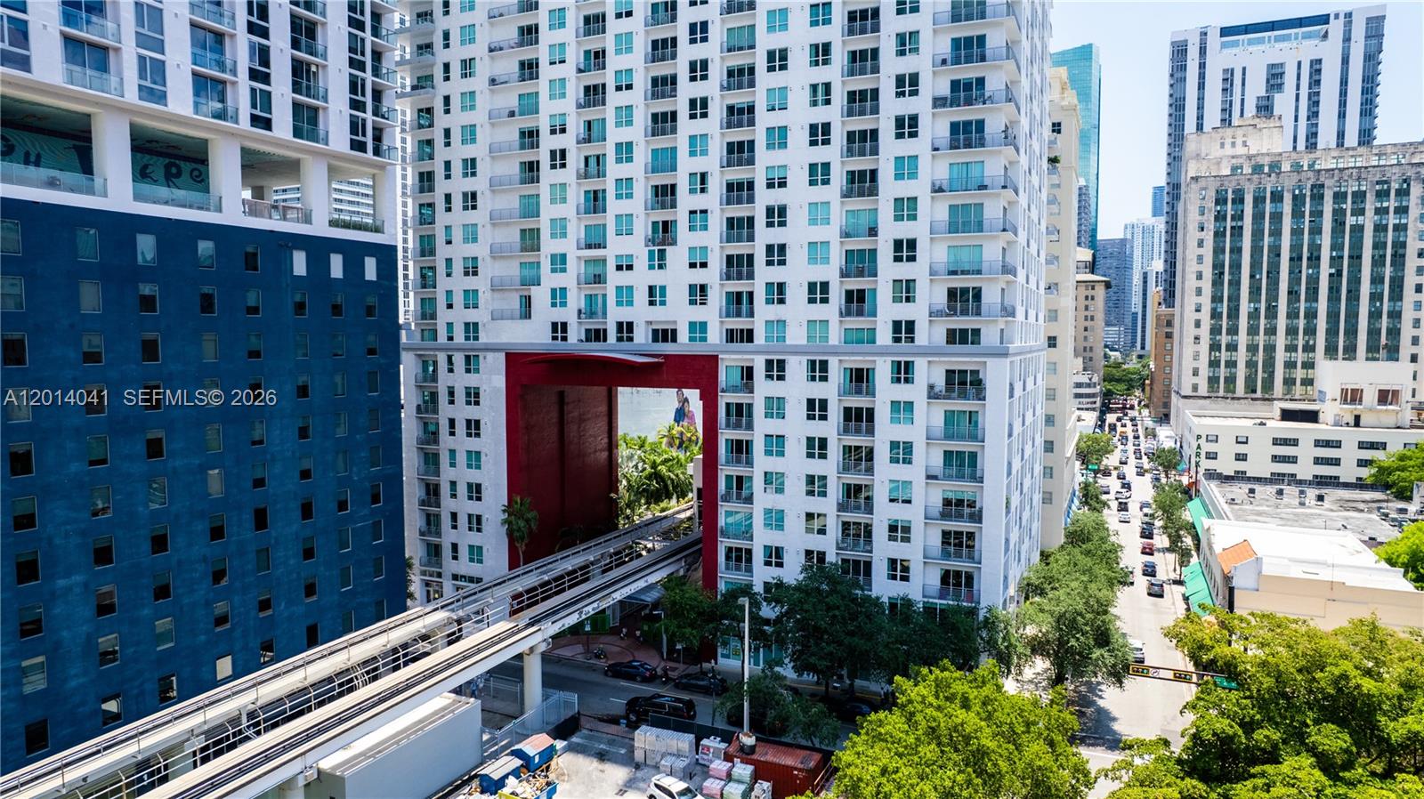 An elevated train track passes through a large red archway between two high-rise buildings — 133 NE 2nd Ave # 609, Miami FL 33132, MIAMI, FL