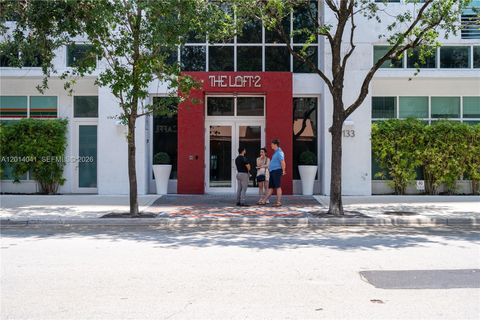 The exterior entrance of a building named The Loft 2 with three people standing outside — 133 NE 2nd Ave # 609, Miami FL 33132, MIAMI, FL