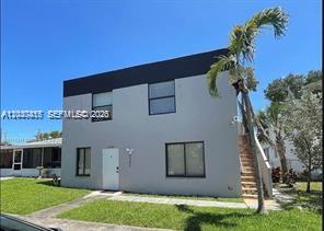 A two-story gray building with a flat roof, white door, and a palm tree outside — 2240 Simms St # 3, Hollywood FL 33020, HOLLYWOOD, FL