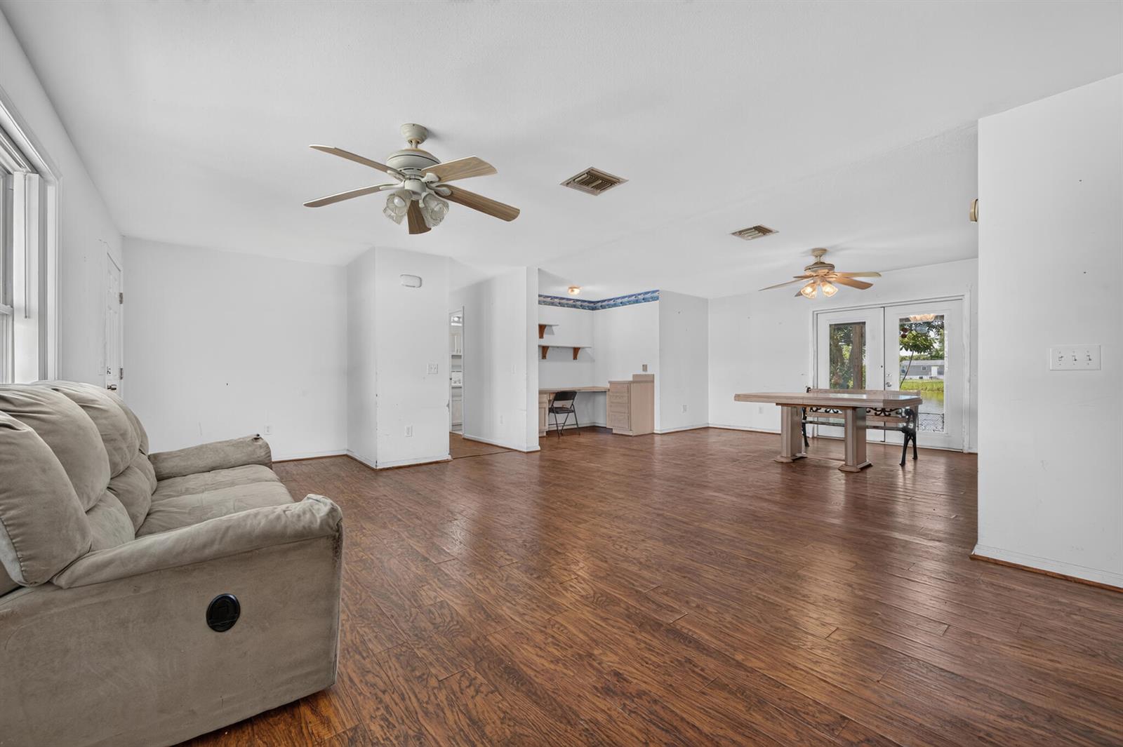 A living and dining area features white walls, wood-look flooring, two ceiling fans, and furniture — 2546 SE 27th Street, Okeechobee FL 34974, OKEECHOBEE, FL