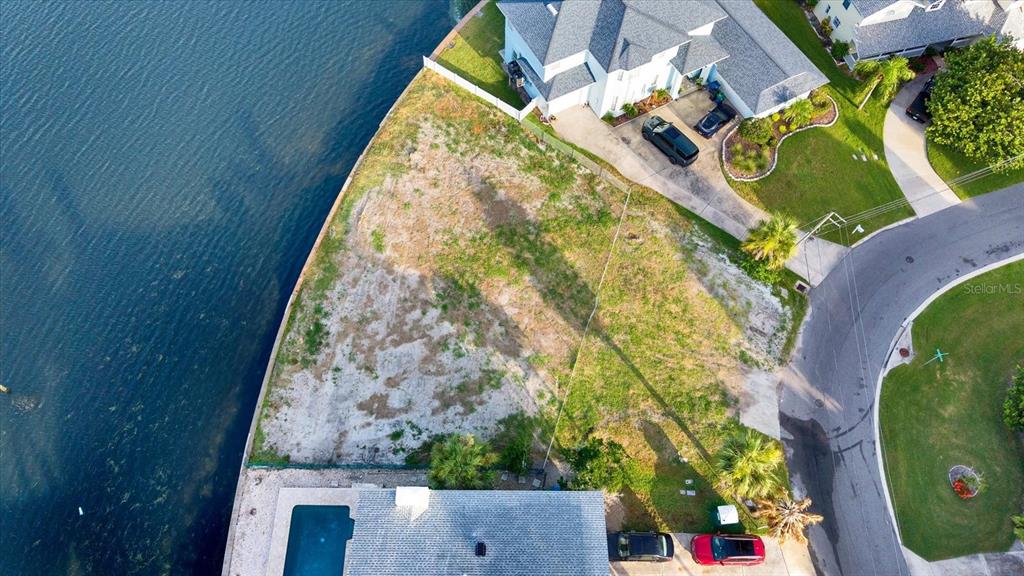 An aerial view shows a vacant waterfront lot situated between two existing residential properties — 121 AUGUSTA AVENUE, PALM HARBOR, FL