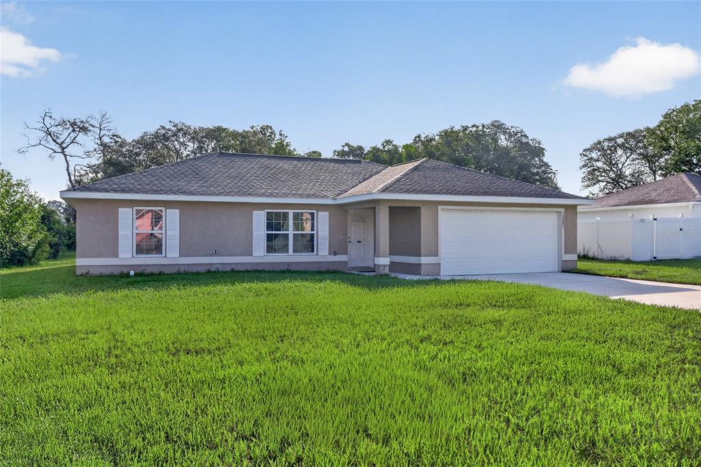 An aerial view of a single-story house with a white garage and a concrete driveway — 13881 SW 33RD TERRACE, OCALA, FL