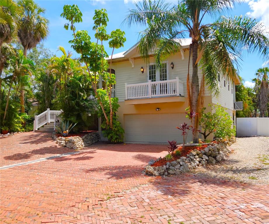 A two-story house with a brick driveway, a garage, and a second-floor balcony — 102 17TH STREET NE, BRADENTON, FL