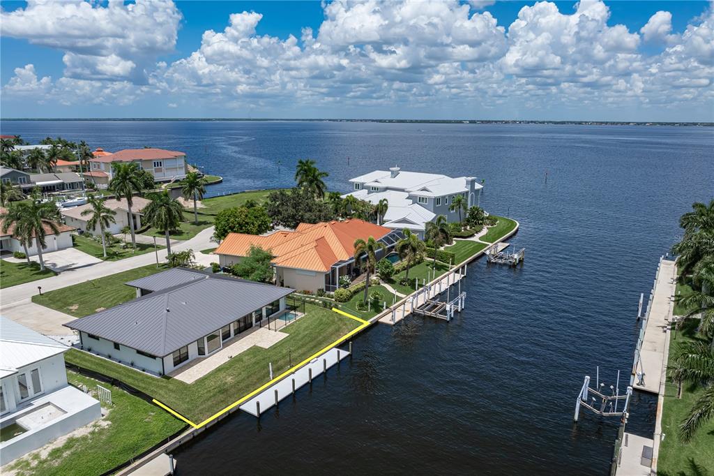 An aerial view shows a waterfront house with a metal roof and a private dock — 12 SABAL DRIVE, PUNTA GORDA, FL