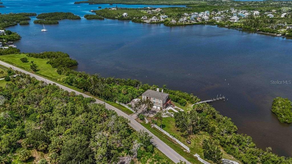 An aerial view shows a house situated on a waterfront lot with a private dock — 1460 BAYSHORE DRIVE, TERRA CEIA, FL