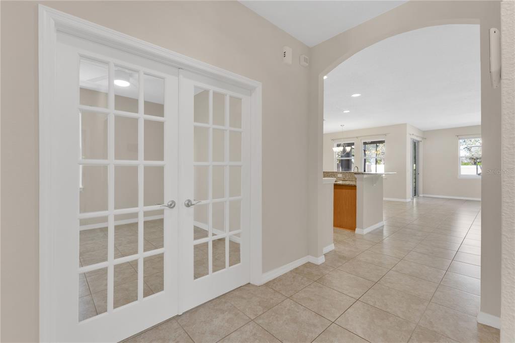 A tiled entryway leads to a room with French doors and an open-concept living area — 244 WHIRLAWAY DRIVE, DAVENPORT, FL
