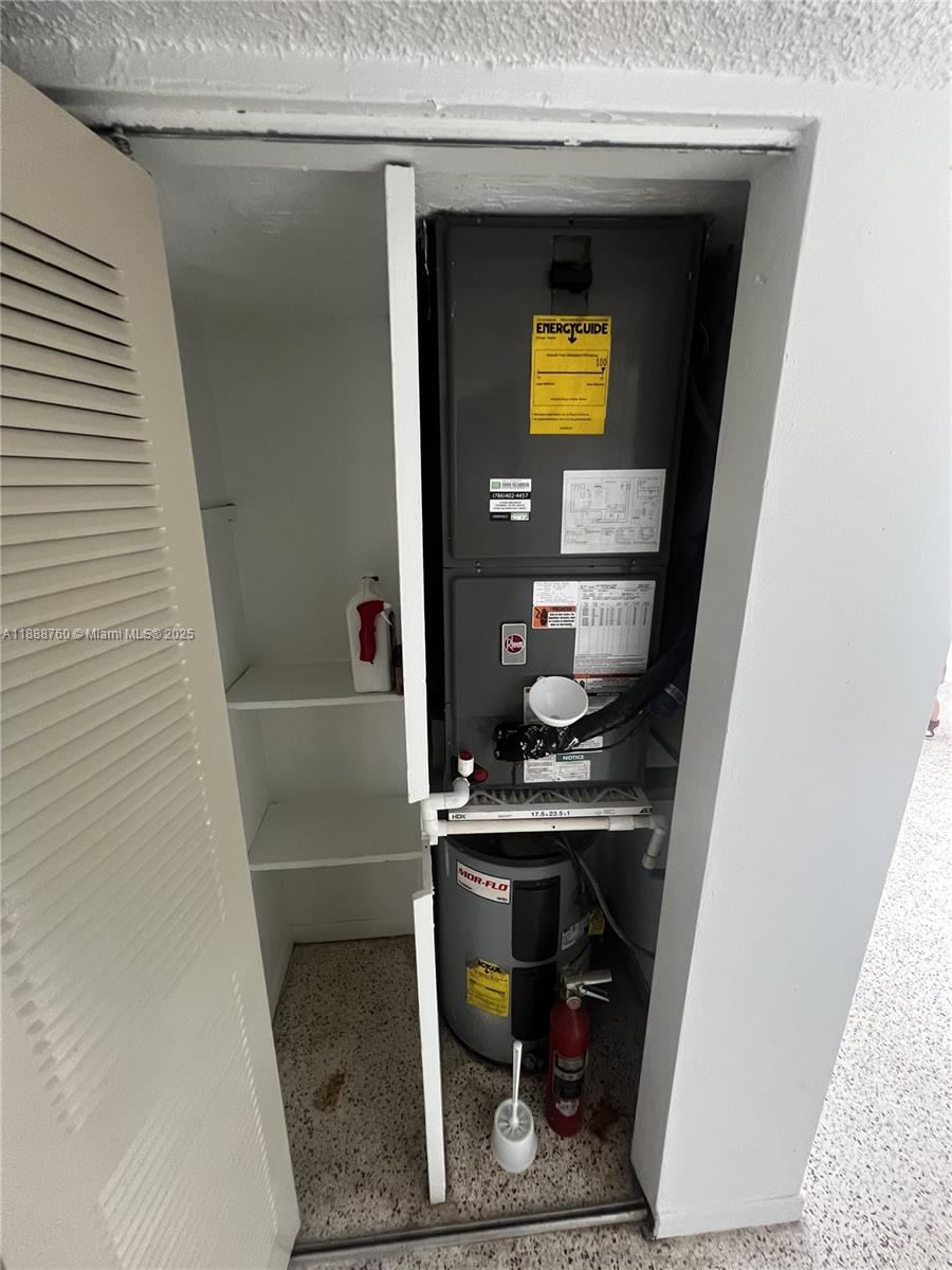 A utility closet contains a Rheem air handler unit stacked above a Mor-Flo water heater — 619 SW 11th Ave # 2, Miami FL 33130, MIAMI, FL