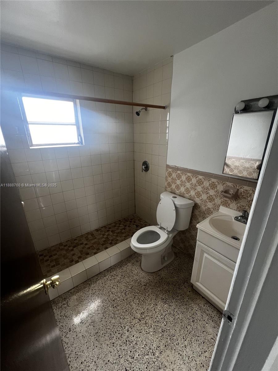 A bathroom features a walk-in shower with tiled walls, a toilet, and a small vanity — 619 SW 11th Ave # 2, Miami FL 33130, MIAMI, FL