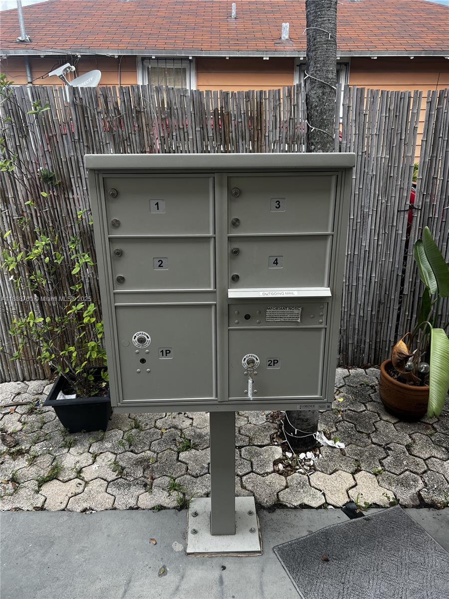A gray metal pedestal mailbox with six compartments stands on a paved patio — 619 SW 11th Ave # 2, Miami FL 33130, MIAMI, FL