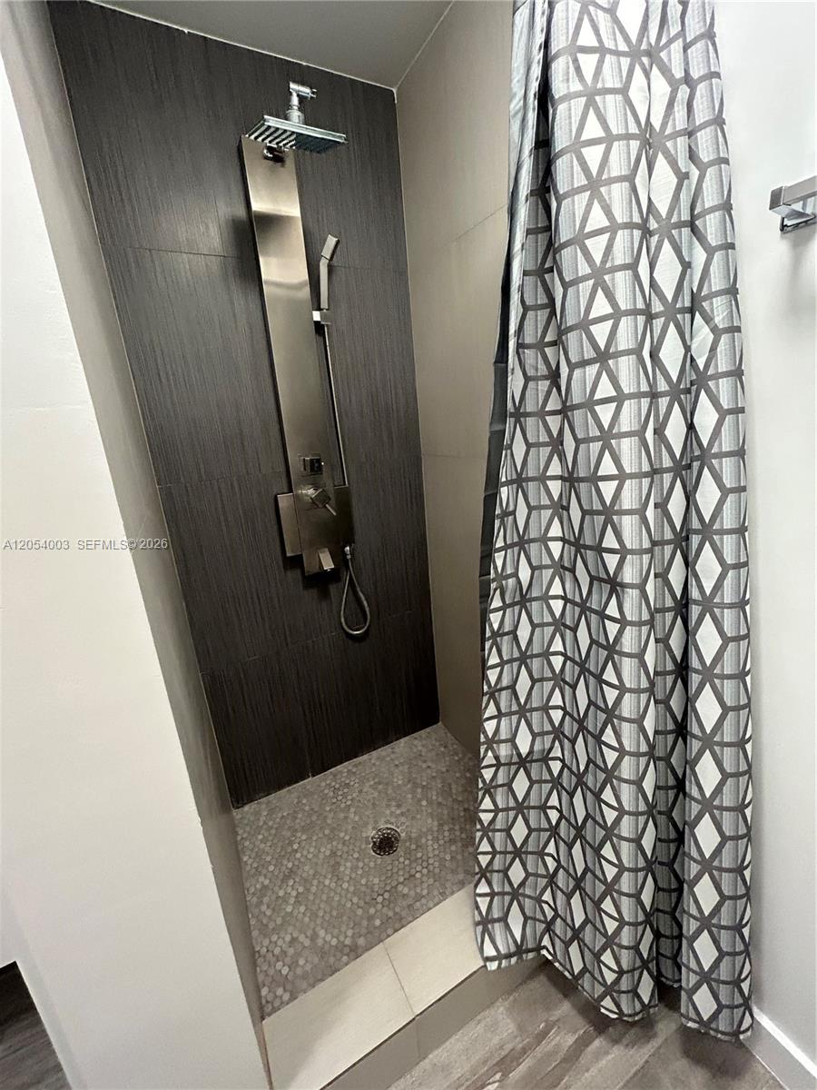 A walk-in shower features a rainfall showerhead, a handheld sprayer, and a pebble-tiled floor — 1035 Euclid Ave # 27, Miami Beach FL 33139, MIAMI BEACH, FL