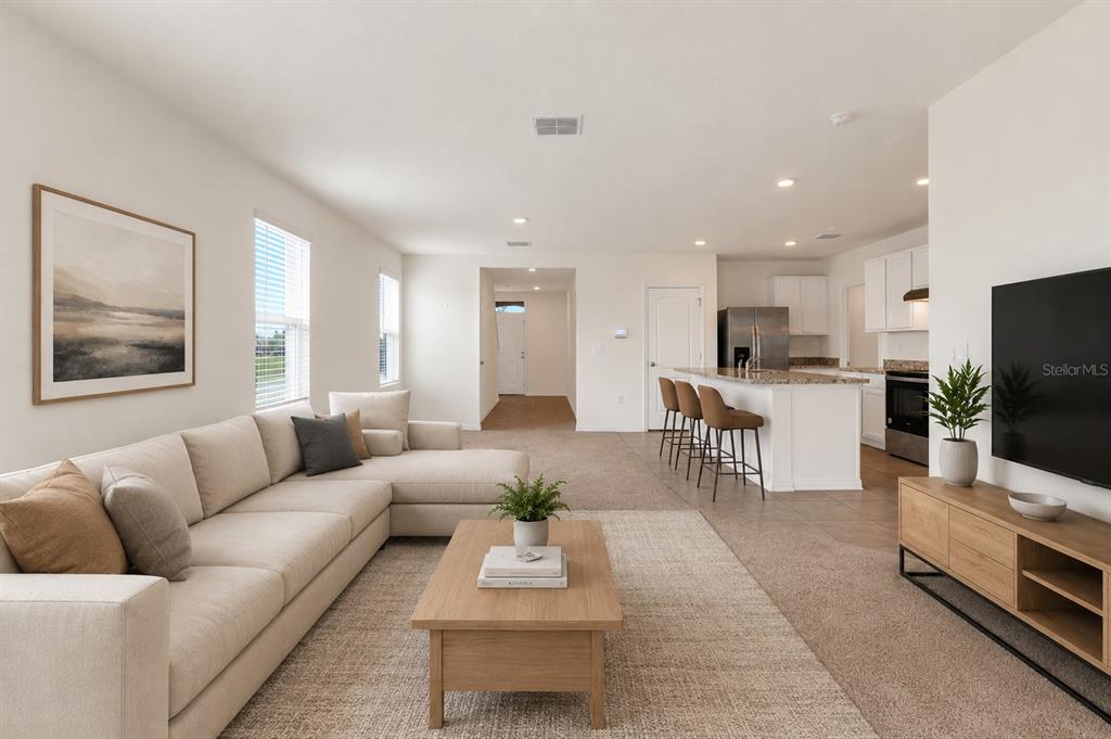 A living room with a sectional sofa, coffee table, and open kitchen with a breakfast bar — 1923 ELKRIDGE ST, DAVENPORT, FL