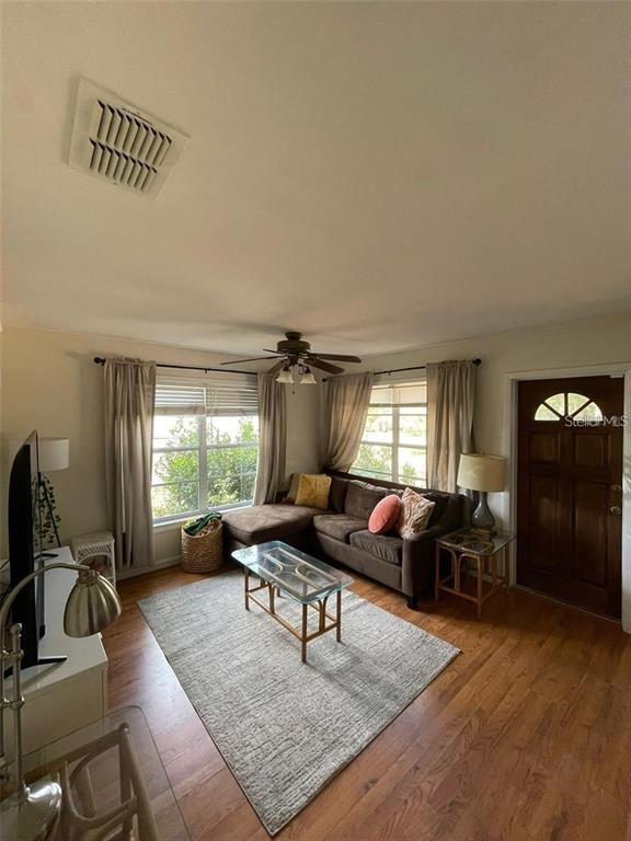 A room with dark tile flooring, a window, a mini-split unit, and two doorways — 11707 NORTH DRIVE, TAMPA, FL