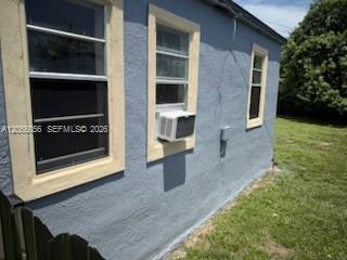 The exterior of a blue stucco house features three windows, one with a window air conditioner — 863 NW 139th St, Miami FL 33168, MIAMI, FL