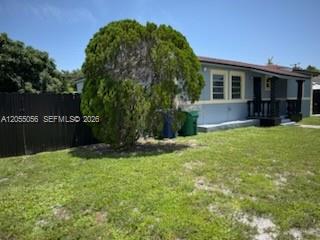 A view of a house exterior with a large green bush and a black fence — 863 NW 139th St, Miami FL 33168, MIAMI, FL