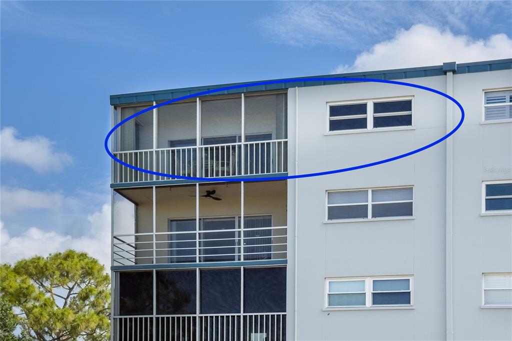 The top floor of a multi-story building features a screened-in balcony and adjacent windows — 3880 IRONWOOD LANE UNIT 508E, BRADENTON, FL