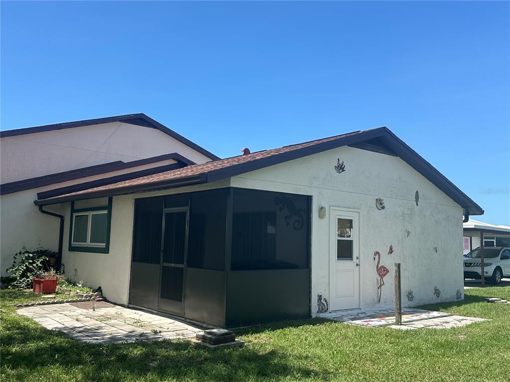A multi-unit residential building with covered parking carports under a sunset sky — 166 CIRCLEWOOD DRIVE UNIT 101, VENICE, FL