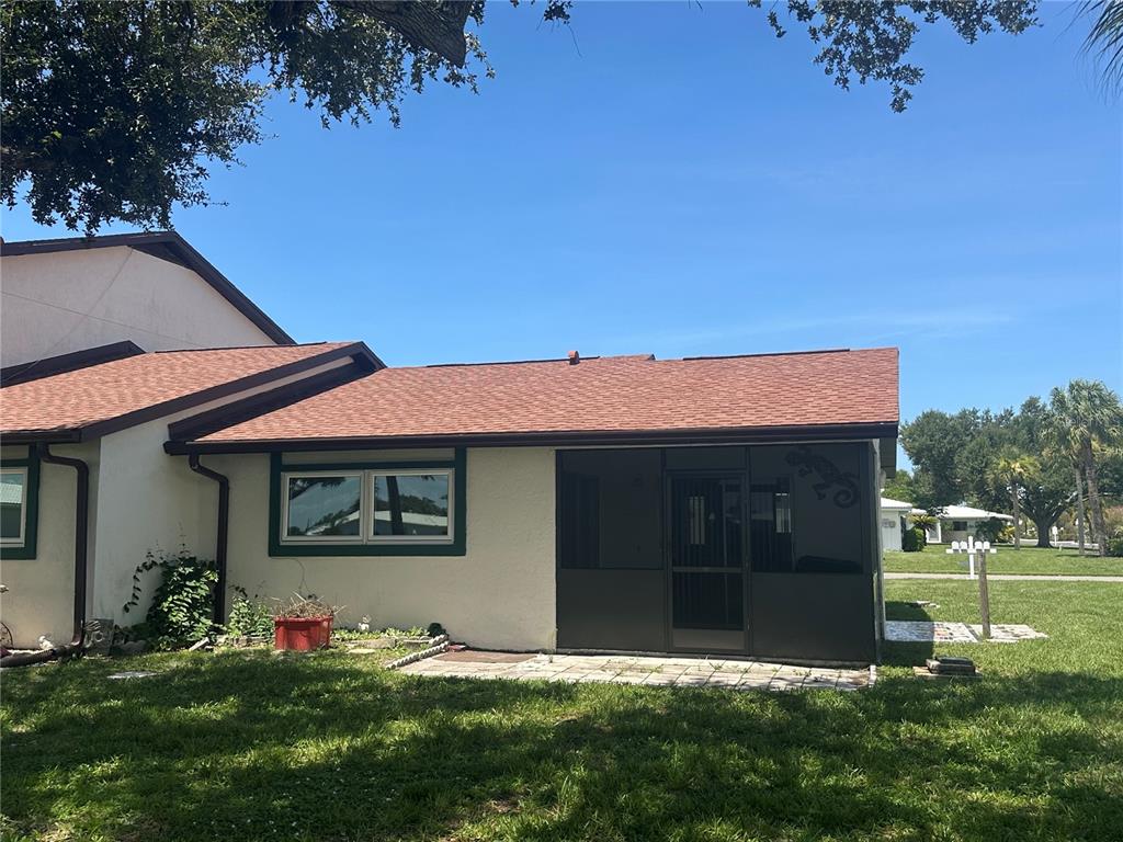 A one-story residential building with a paved patio, green trim, and a palm tree — 166 CIRCLEWOOD DRIVE UNIT 101, VENICE, FL