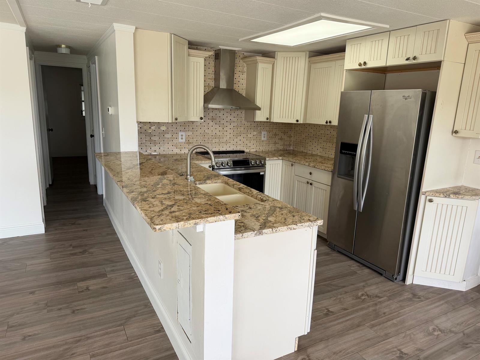 A kitchen features white beadboard cabinets, granite countertops, stainless steel appliances, and wood-look flooring — 2041 SW 84th Avenue, Davie FL 33324, DAVIE, FL
