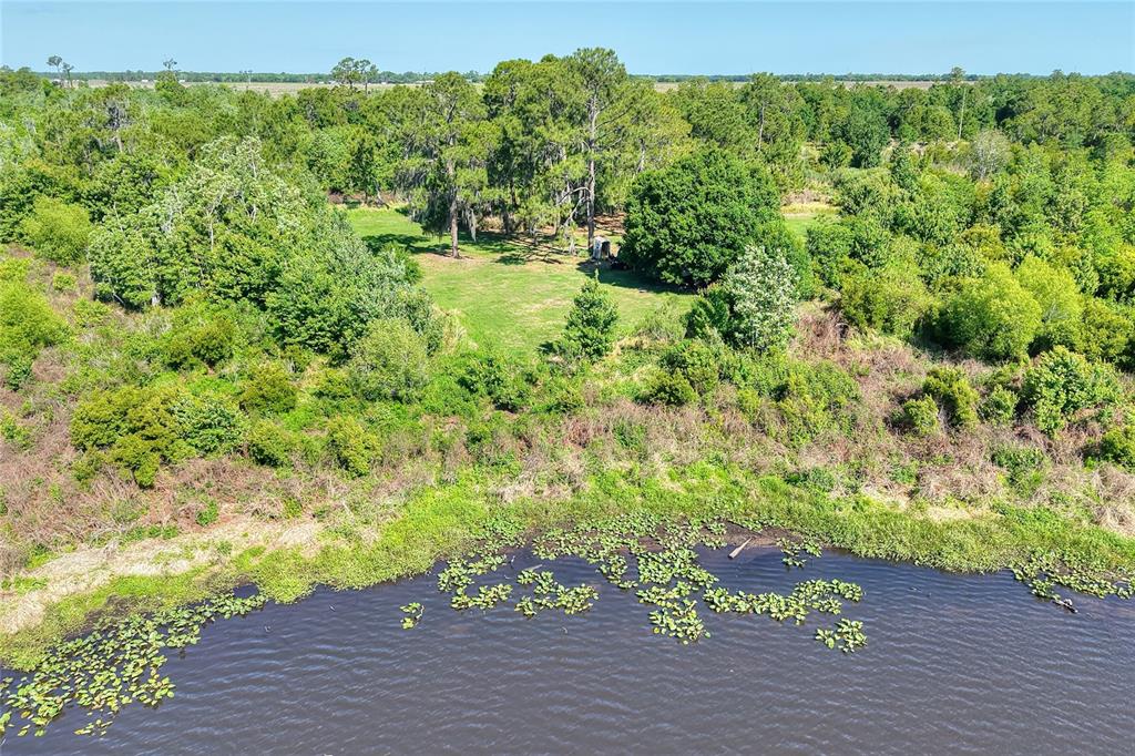 An aerial view shows a grassy clearing with a small shed surrounded by dense woods — 0 LAKE BUFFUM ROAD W, FORT MEADE, FL