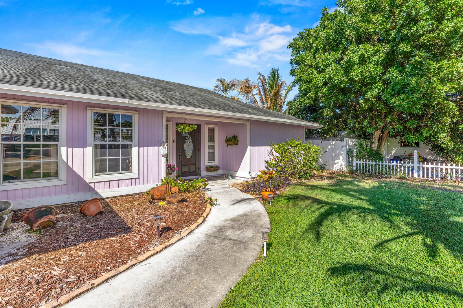 A light purple house with a concrete walkway leading to the front door and lawn — 4153 Russell Street, Jupiter FL 33469, JUPITER, FL