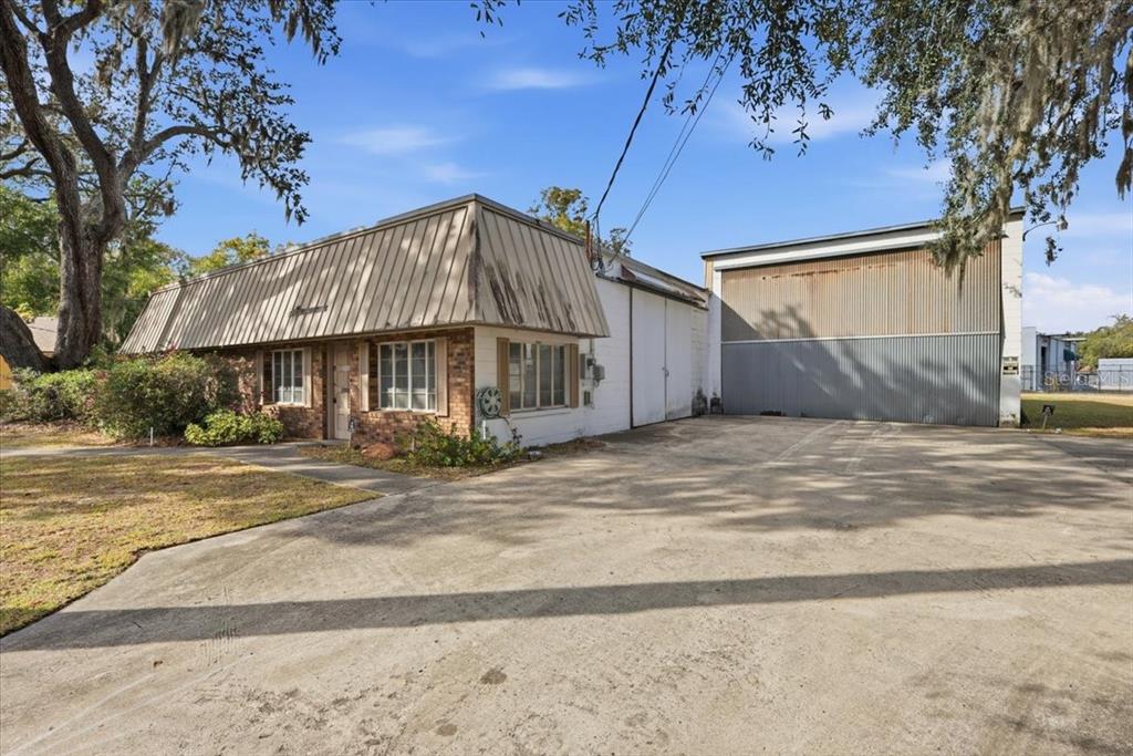 A single-story commercial building with a brick facade and an attached metal warehouse bay — 1022 WILFRED DRIVE, ORLANDO, FL