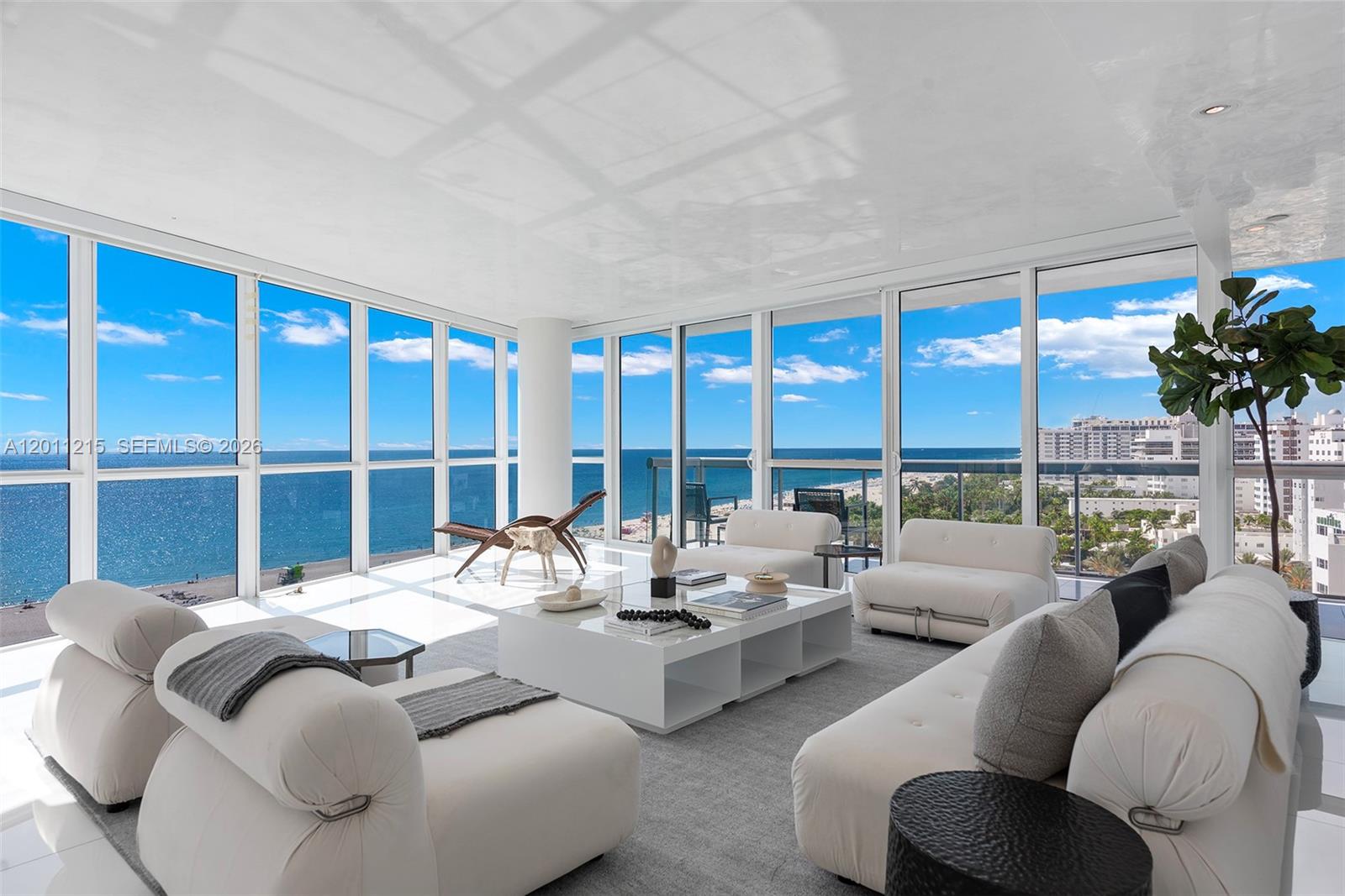 A bright living room features white furniture, a central coffee table, and floor-to-ceiling ocean views — 101 20th St # 1707, Miami Beach FL 33139, MIAMI BEACH, FL