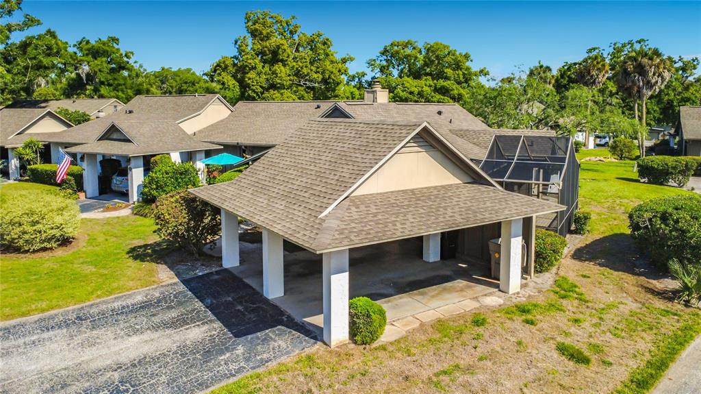 An aerial view of a house with a large covered carport and a screened-in patio — 1921 ABBINGTON STREET UNIT 23C, APOPKA, FL