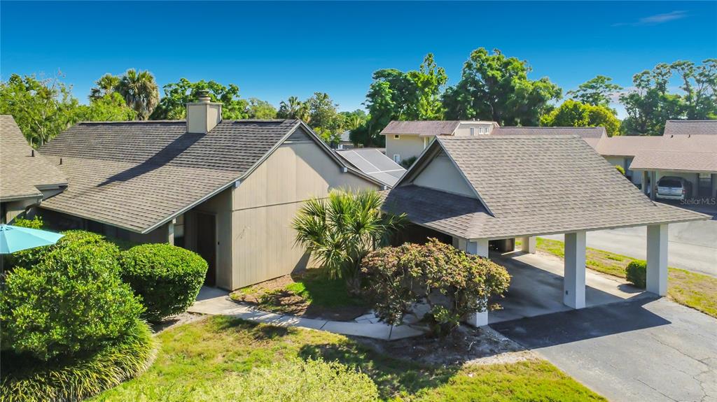 An exterior view of a house with a shingled roof and an attached carport — 1921 ABBINGTON STREET UNIT 23C, APOPKA, FL