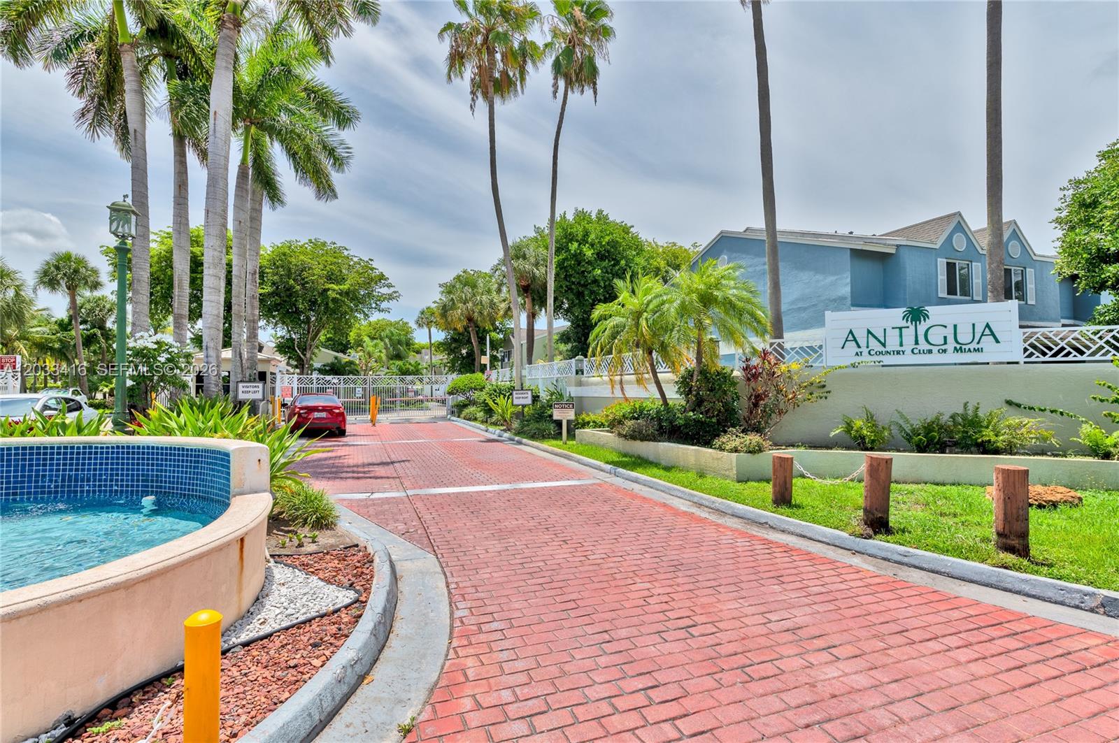 A gated entrance with a brick driveway leads to the Antigua at Country Club of Miami — 17485 NW 67th Ct # 21, Hialeah FL 33015, HIALEAH, FL