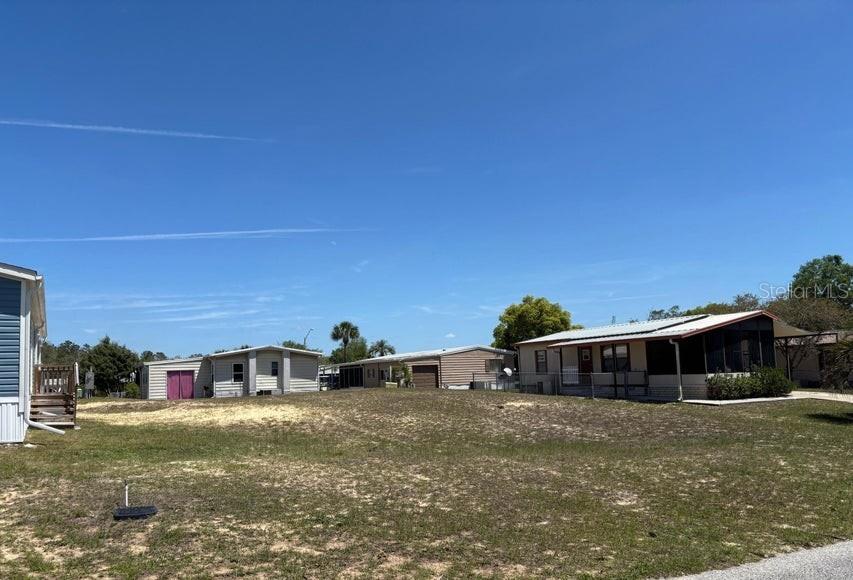 A view of several manufactured homes situated on a large, grassy, sandy lot — 14405 DIABLO DRIVE, BROOKSVILLE, FL