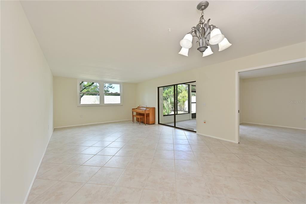 A backyard area features a stone path, dark mulch, a cactus, and a sunroom — 609 WOODLAWN DRIVE, BRADENTON, FL