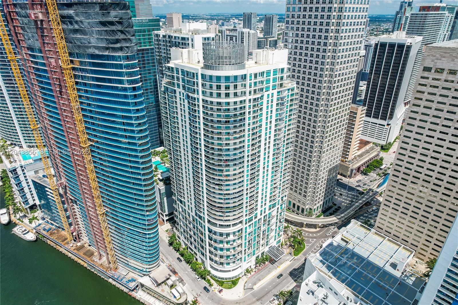A modern living room features a velvet sofa, floor-to-ceiling windows, and a view of skyscrapers — 300 S Biscayne Blvd # 612, Miami FL 33131, MIAMI, FL