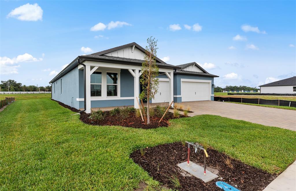 A single-story house with a blue exterior, white trim, and a two-car garage — 16518 ENNIS PLACE, BRADENTON, FL