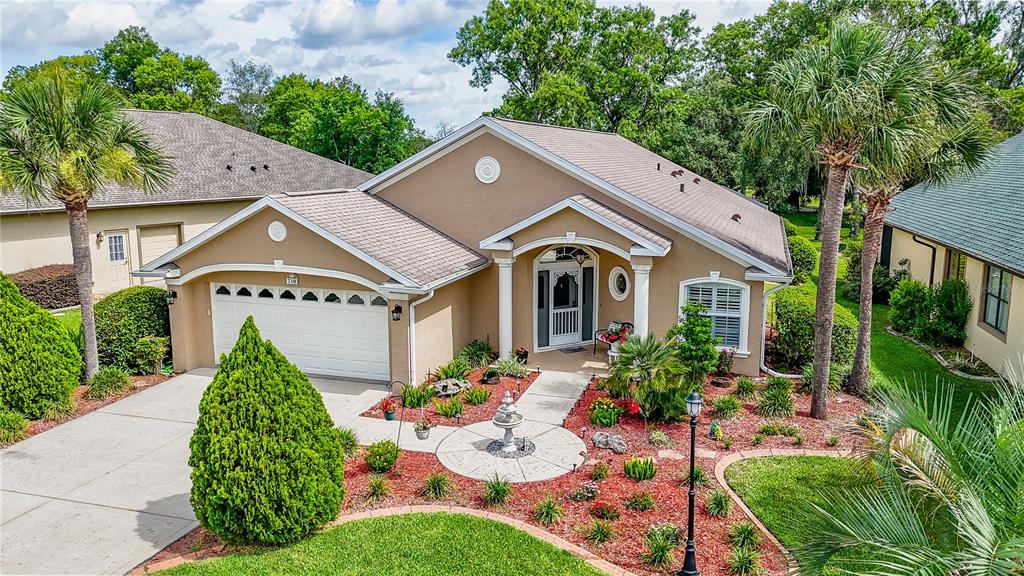 An exterior view of a tan, single-story suburban house with a two-car garage — 710 LAKE DIAMOND AVENUE, OCALA, FL