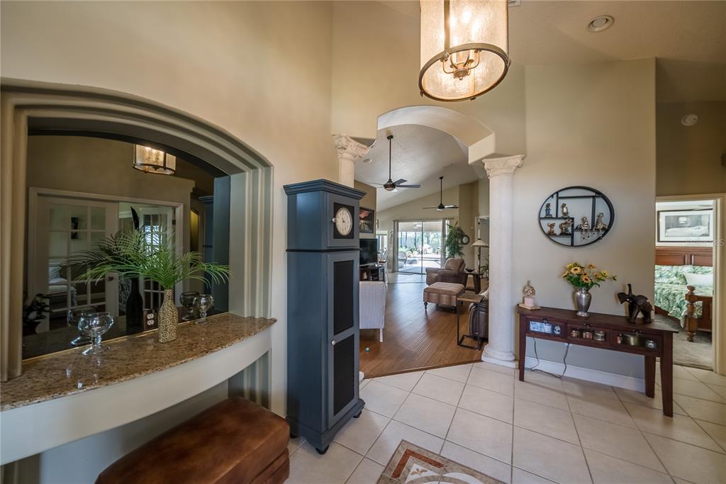 A tiled entryway features a granite-topped pass-through window, a tall blue cabinet, and arched columns — 710 LAKE DIAMOND AVENUE, OCALA, FL