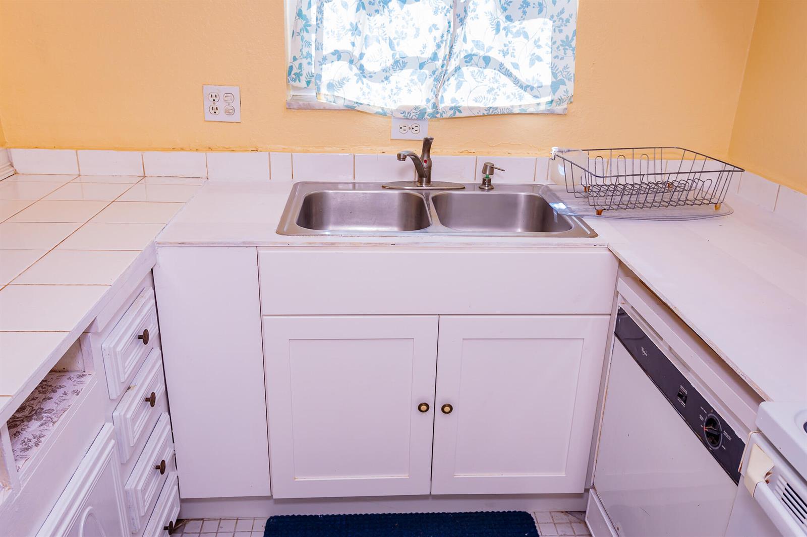 A kitchen features a double-basin stainless steel sink, white cabinets, and tiled countertops — 3240 Ridge Hill Road # C, Boynton Beach FL 33435, BOYNTON BEACH, FL