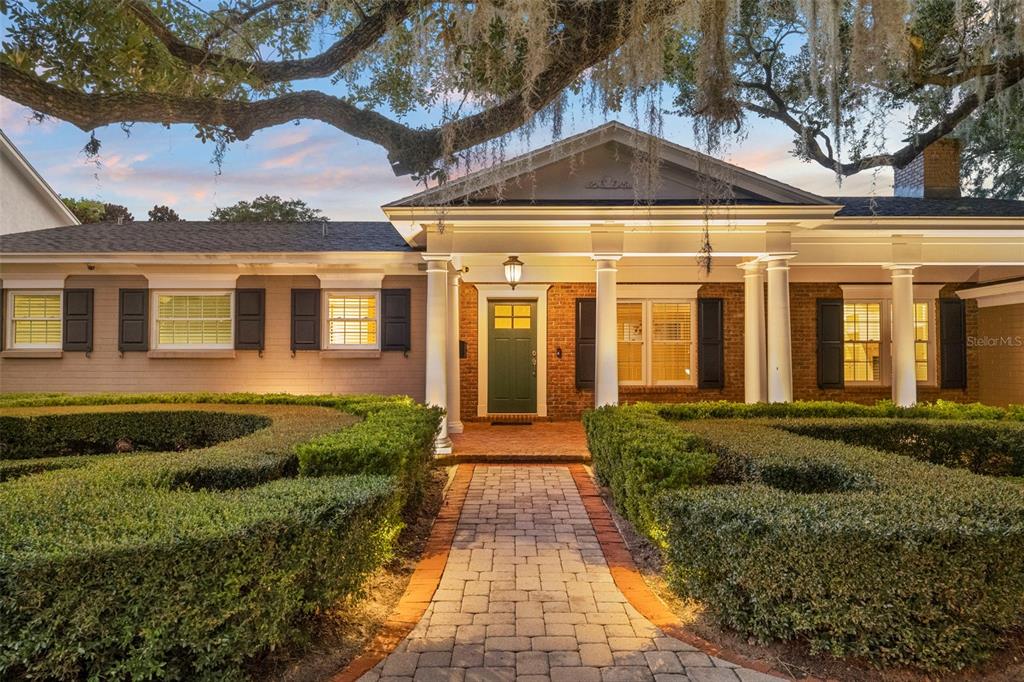 A brick house with a columned porch and a paved walkway through manicured hedges — 2410 LAKE SHORE DRIVE, ORLANDO, FL