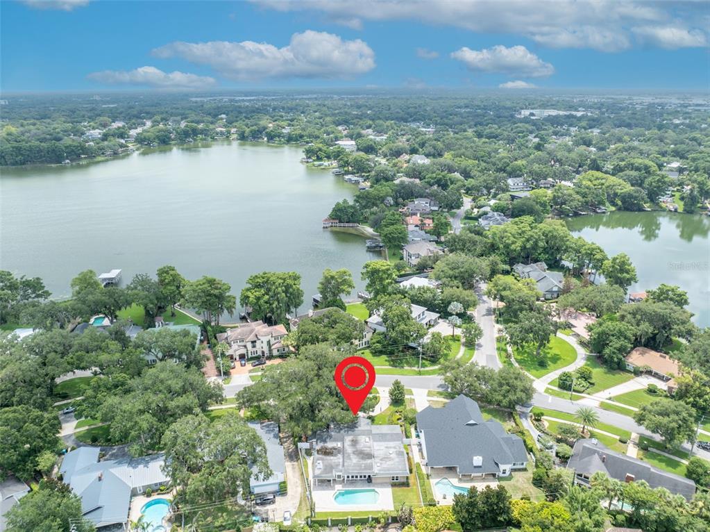 An aerial view shows a residential property with a swimming pool near a large lake — 2410 LAKE SHORE DRIVE, ORLANDO, FL
