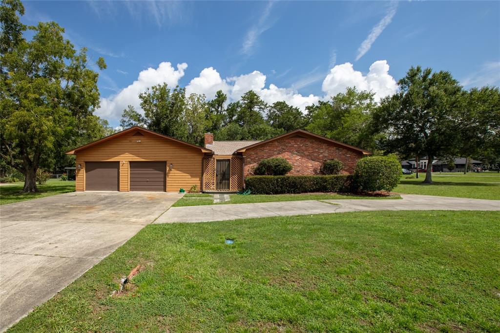 A single-story house with a brick facade, wood siding, and an attached two-car garage — 1619 RAIFORD ROAD, STARKE, FL