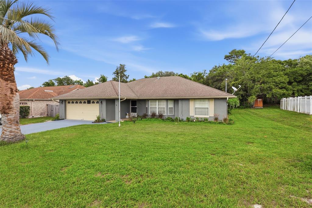 A single-story gray house with a tan garage door and a large front lawn — 2307 FITZPATRICK TERRACE, DELTONA, FL