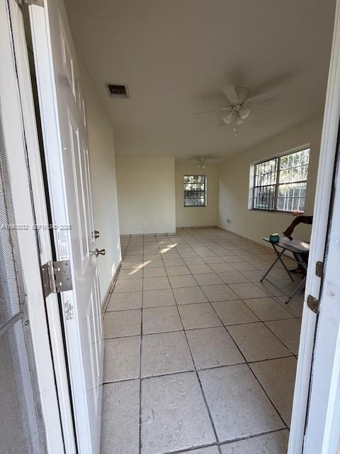 An interior view of a tiled room featuring a ceiling fan and two windows — 14620 Monroe St # x, Miami FL 33176, MIAMI, FL