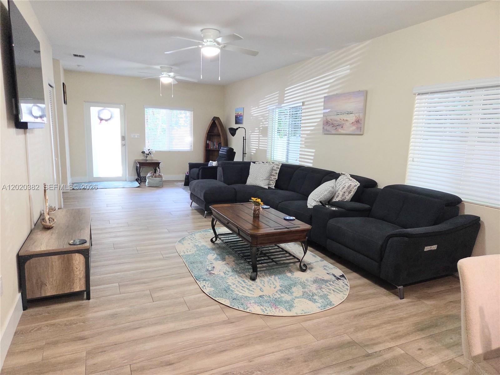 A living room features a large dark sectional sofa, a wooden coffee table, and light flooring — 11 Pompano Ave # 11, Key Largo FL 33037, KEY LARGO, FL