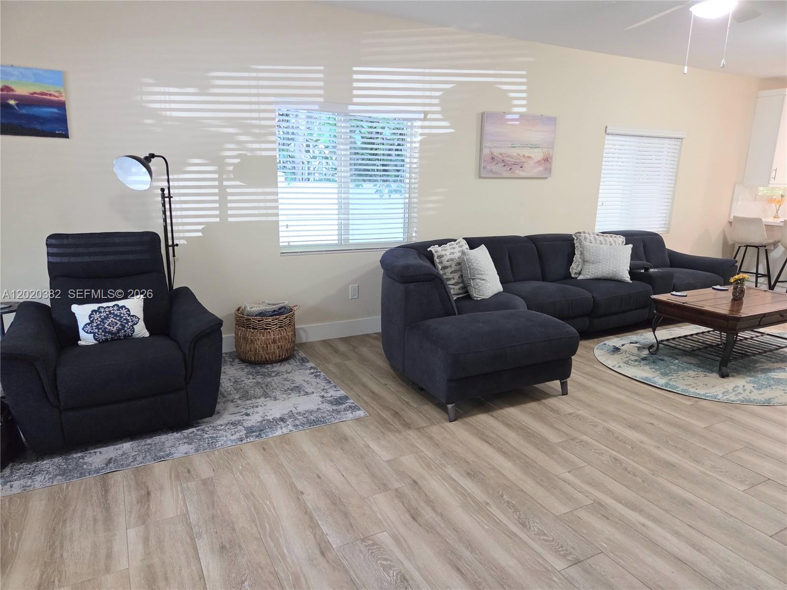 A living room features a dark sectional sofa, a matching recliner, and light wood flooring — 11 Pompano Ave # 11, Key Largo FL 33037, KEY LARGO, FL