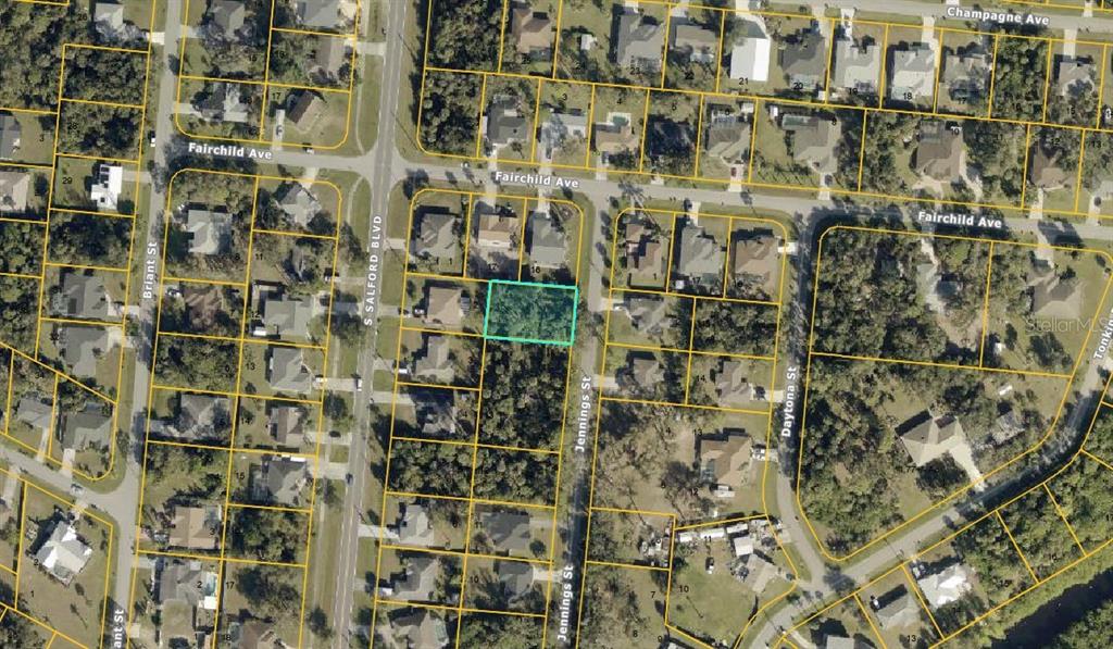 This is an aerial map showing a vacant, wooded residential lot highlighted in light blue — Lot #15 JENNINGS STREET, NORTH PORT, FL