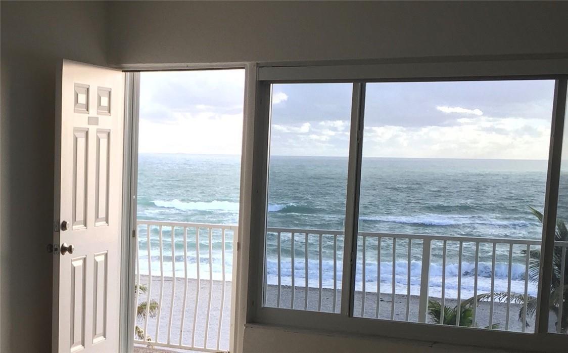 A room with a white door and large windows overlooking the ocean and a balcony — 300 E Oregon Street E # 303, Hollywood FL 33019, HOLLYWOOD, FL