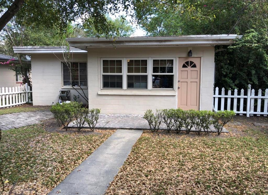 A single-story house with a beige exterior, a light-colored door, and a white picket fence — 826 N WESTMORELAND DRIVE, ORLANDO, FL