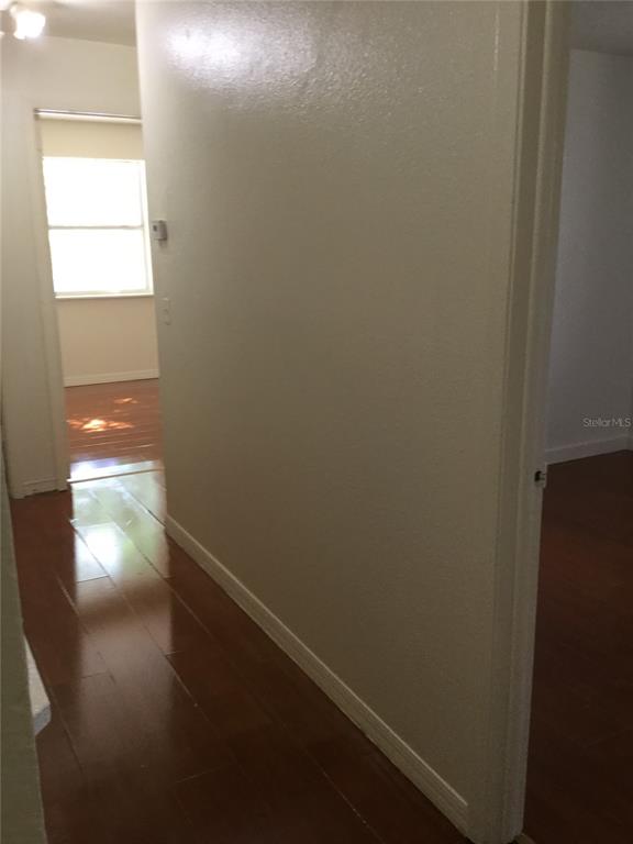 A hallway with hardwood flooring leads to a room with a window — 2454 RIO PINAR LAKES BOULEVARD, ORLANDO, FL